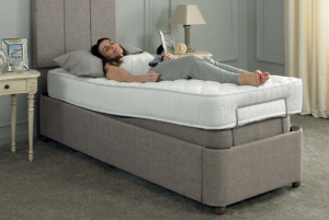 A woman using an adjustable bed to sleep with legs raised. 