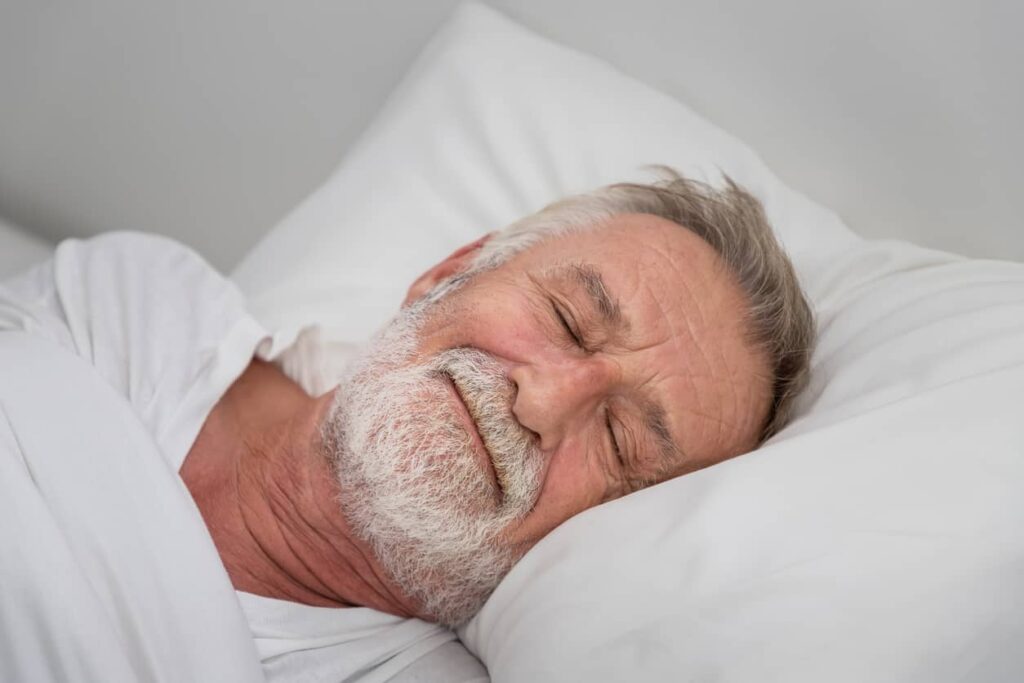 A man sleeps peacefully on a clean bed