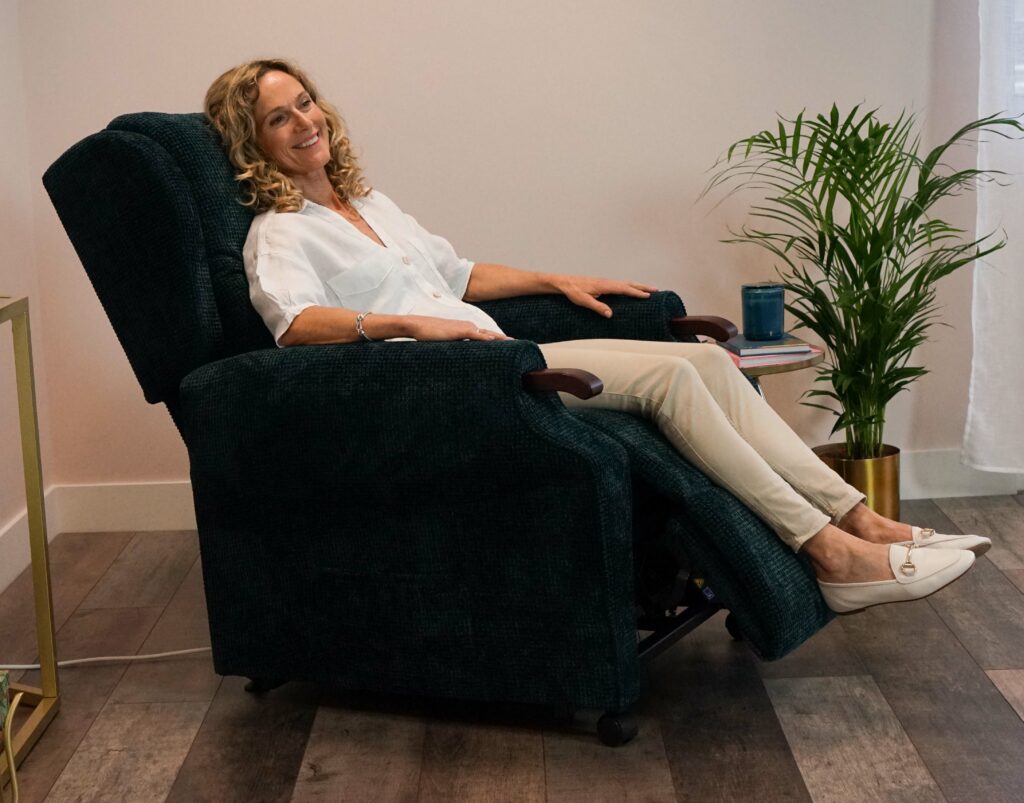Woman relaxes in a riser recliner chair.
